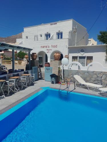 a pool in front of a restaurant with a building at Villa Markos in Perissa