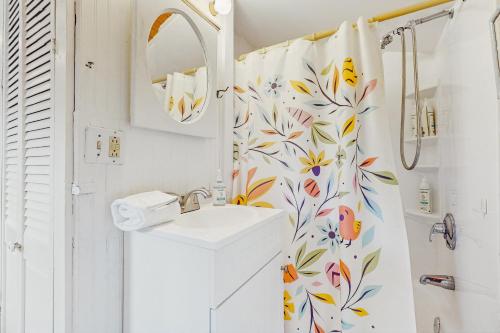 a bathroom with a sink and a shower curtain at The Beach Bunny Cottage in Plymouth