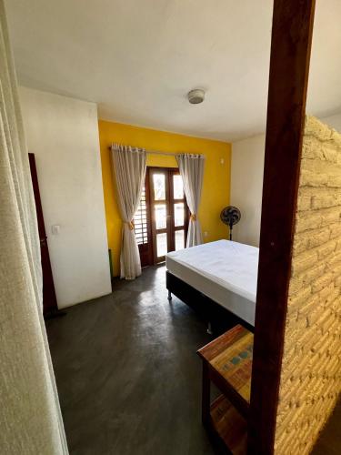 a bedroom with a bed in a room with yellow walls at Casa Kuara in Trairi