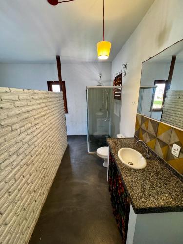a bathroom with a sink and a toilet and a mirror at Casa Kuara in Trairi