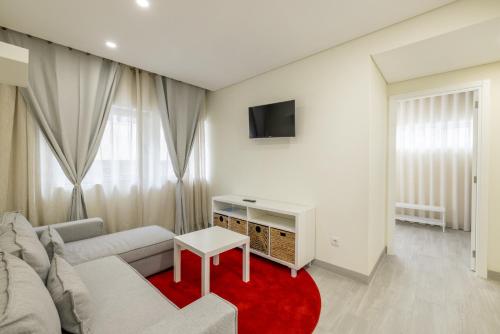 a living room with a white couch and a red rug at D&S - Torne Apartments in Vila Nova de Gaia