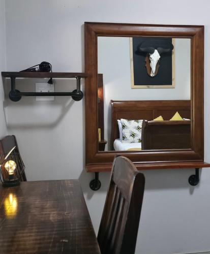 a mirror in a room with a table and a bed at Ukulala Inn in Malelane