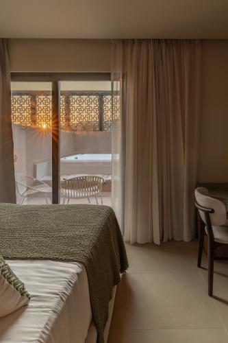a hotel room with a bed and a balcony at Eleonas Boutique Hotel & Spa - Adults Only in Ialysos