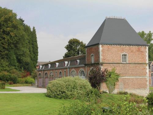 un grand bâtiment en briques avec un toit noir dans l'établissement Holiday home for 10 people set in castle grounds, à Barvaux-Condroz