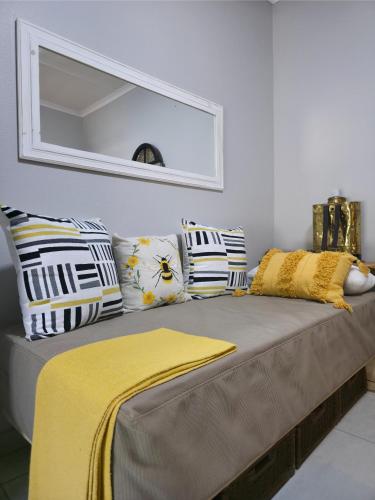 a bed in a room with pillows and a mirror at Ukulala Inn in Malelane
