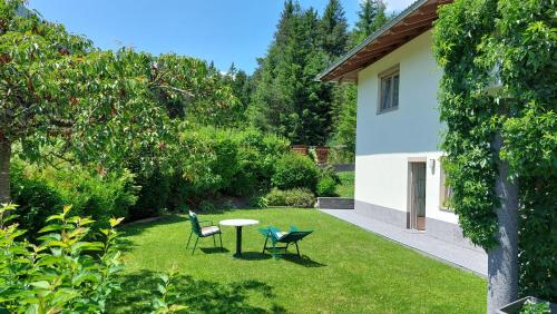 a garden with two chairs and a table in the grass at Haus Monika in Obsteig