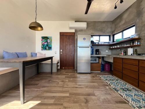 a kitchen with a table and a refrigerator at La Ventana Hostel in La Ventana
