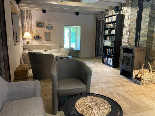un soggiorno con poltrona e camino di Domaine de Vandenesse Et Spa a Vandenesse-en-Auxois