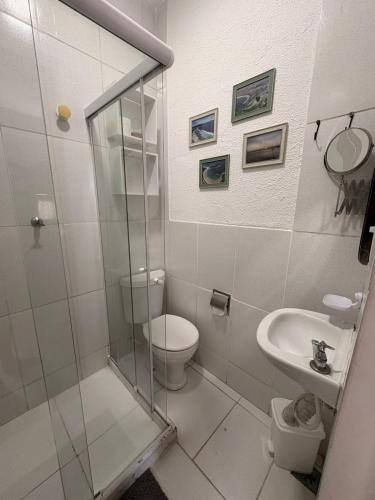 a bathroom with a shower and a toilet and a sink at Pousada Cantinho de Minas Da Tânia in Cabo Frio