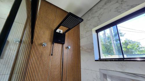 a shower in a bathroom with a window at Casa Espetacular, 3 suites, luxo! in Maringá