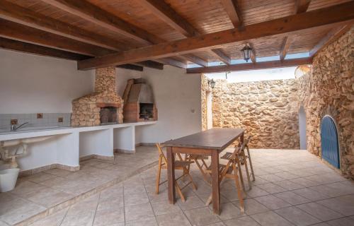 a kitchen with a table and a stone wall at Villa Angela - Ginevra in LMP