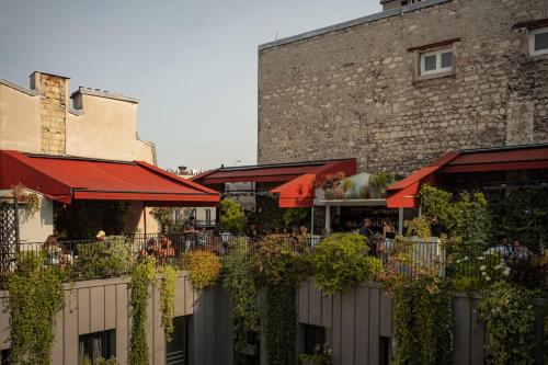 a restaurant with red umbrellas next to a building at Grands Boulevards Experimental in Paris