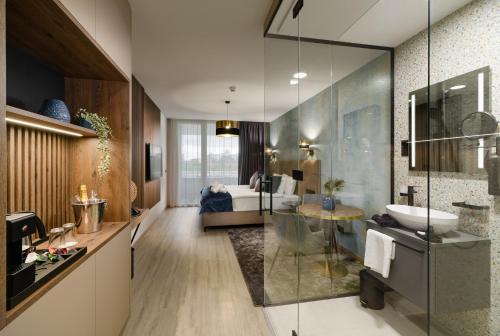 a bathroom with a tub and a sink and a bed at INFINITY Budapest Hotel in Budapest