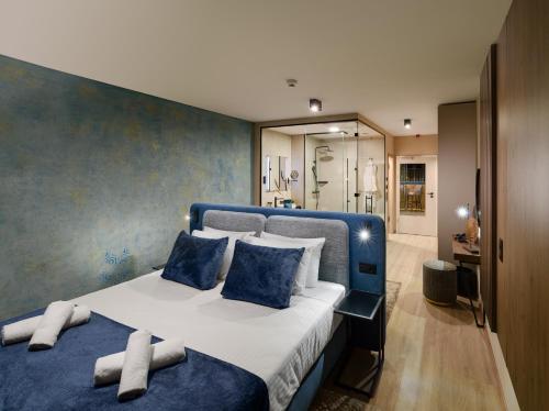 a bedroom with a blue and white bed and a bathroom at INFINITY Budapest Hotel in Budapest