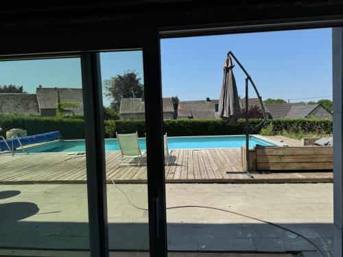 a view of a swimming pool through a window at Ferme de Filot 2 in Filot