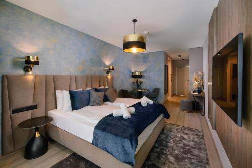 a bedroom with a large bed with a blue wall at INFINITY Budapest Hotel in Budapest
