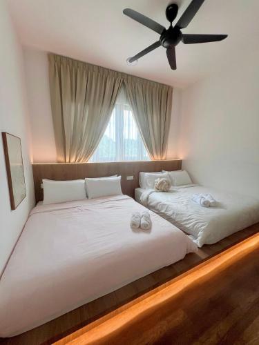 a bedroom with two beds and a ceiling fan at 2-8pax Ipoh Nomado Onsen suites by Sunway Onsen Lost world of Tambun in Ipoh