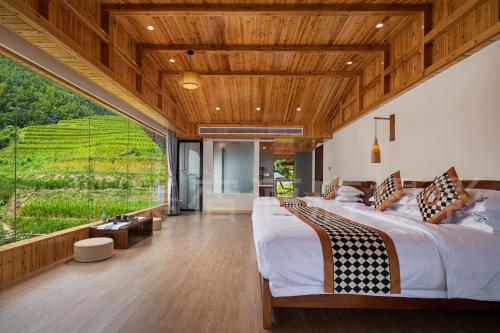 和平乡Longsheng Xichuangyue B&B Hotel的一间有两张床和一扇大窗户的卧室