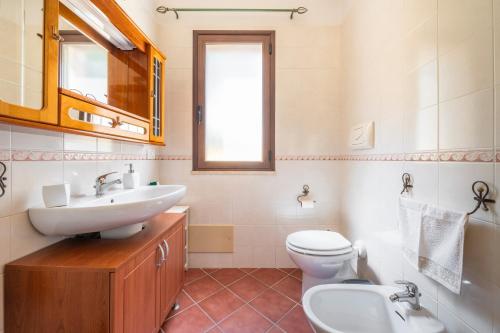 a bathroom with a sink and a toilet and a mirror at Casa Mameli in Quartucciu