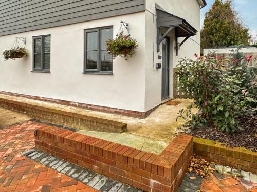 a house with a brick retaining wall in front of it at The Annexe in Guilsfield