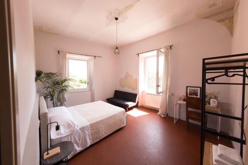 a bedroom with a bed and a chair and windows at Aretium in Arezzo