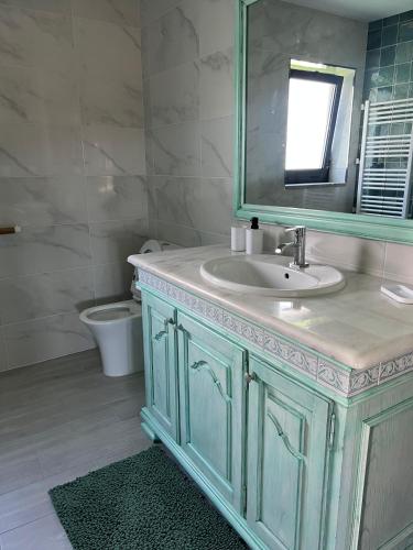 a bathroom with a sink and a mirror and a toilet at Cantinho Sto Amaro in Arcos de Valdevez