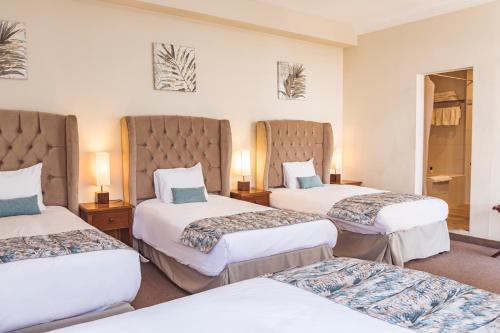 a hotel room with two beds and two lamps at Hostal Lirium in Arequipa