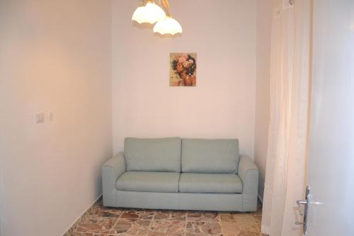 a blue couch in a corner of a room at Un passo dalla vetta in Monte Flavio