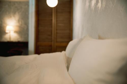 a close up of a bed with white sheets and pillows at 紡舎 - BO-SHA - - 古民家一棟貸しVilla in Akiruno