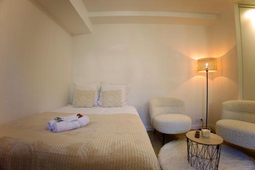 a room with a bed and two chairs and a lamp at Le Dreamy - Terrasse et parking in Albertville