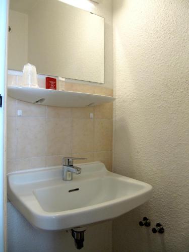 a bathroom with a white sink and a mirror at Hôtel de la Grotte in Aix-les-Bains