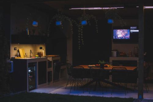 einen Tisch und Stühle in einer Küche mit einem TV in der Unterkunft Meszes Twins in Kalocsa