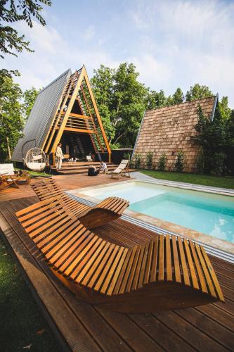 a wooden deck with a swimming pool and a building at Meszes Twins in Kalocsa