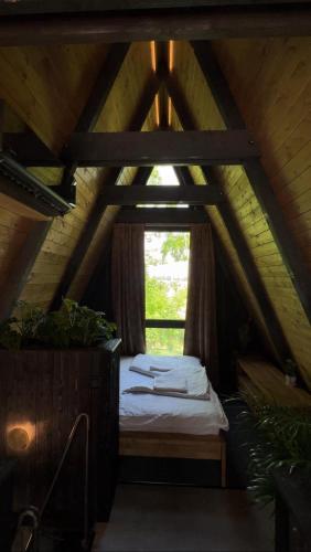 a room with a bed in a attic with a window at Meszes Twins in Kalocsa