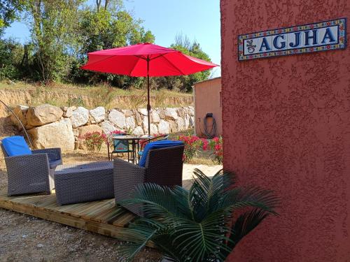 a patio with chairs and an umbrella and a table at chambre d'hôte cosy L'AGHJA in Carbuccia