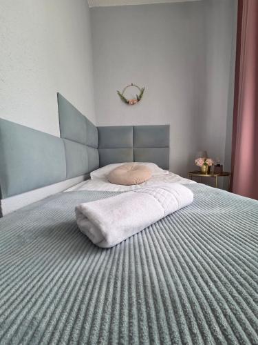 a bedroom with a bed with a pillow on it at Noclegi Gwardia in Koszalin
