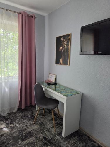 a room with a desk with a chair and a window at Noclegi Gwardia in Koszalin