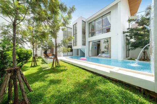 an exterior view of a house with a swimming pool at Sofia Villa Phuket in Phuket