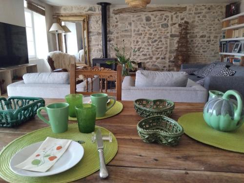 a living room with green plates and bowls on a table at La chambre du lac in Meaux-la-Montagne