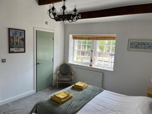 a bedroom with a bed with two towels on it at Railway Cottage Horsforth in Horsforth