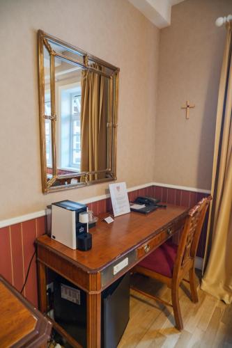 an office with a wooden desk with a mirror at Klosterhotel Wöltingerode in Goslar