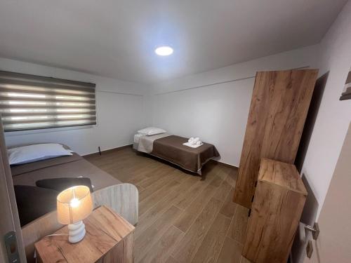 a room with a bed and a table with a lamp at Fred apartment in Nea Fokea