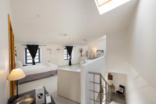 Cette chambre blanche dispose d'un lit et d'un escalier. dans l'établissement C’est une maison bleue, à Carcassonne