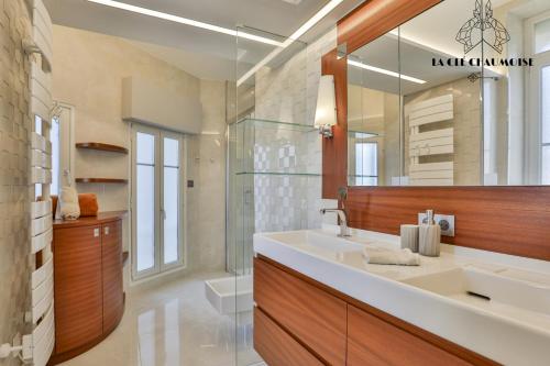 une salle de bain avec un lavabo et un miroir dans l'établissement Villa des Palmiers, à Les Sables-dʼOlonne