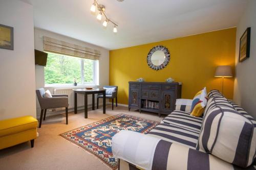 a bedroom with two beds and a table and a window at Outstanding Llangollen Riverside Apartment in Llangollen