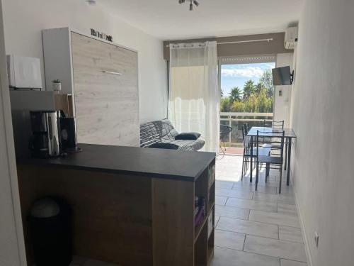 une cuisine et un salon avec une table et un canapé dans l'établissement Charmant Studio Proche Plage, à Valras-Plage