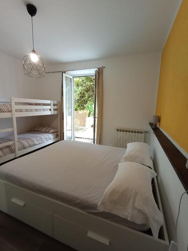 a bedroom with a large white bed and a window at SOTTO LA ROCCA in Finale Ligure