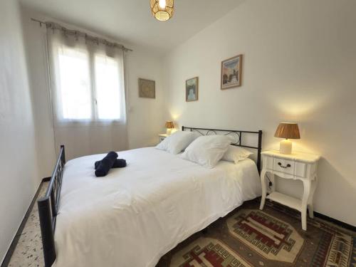 une chambre avec un grand lit blanc et une fenêtre dans l'établissement Valras-Loc Appartement cosy a 300m de la plage, à Valras-Plage