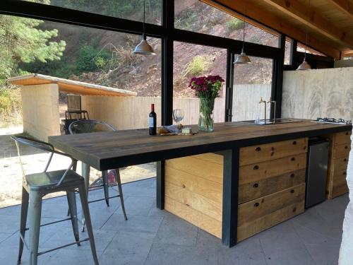 a kitchen with a large wooden counter with a table at Casa La Mina in Valle de Bravo