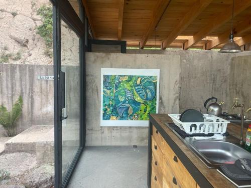 a kitchen with a sink and a painting on the wall at Casa La Mina in Valle de Bravo
